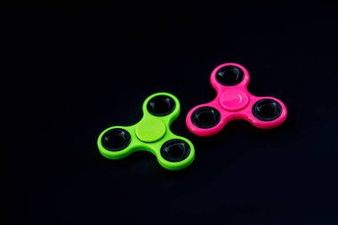 Pembe ve yeşil kıpır Spinner çalışması sırasında stres sürümü için siyah arka plan.