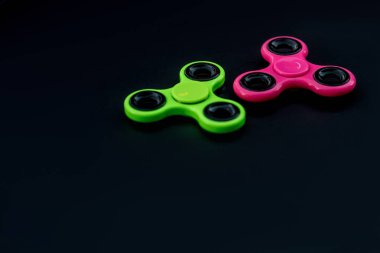 Pembe ve yeşil kıpır Spinner çalışması sırasında stres sürümü için siyah arka plan.