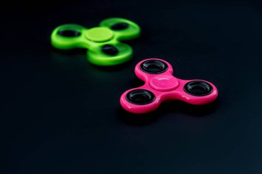 Pembe ve yeşil kıpır Spinner çalışması sırasında stres sürümü için siyah arka plan.