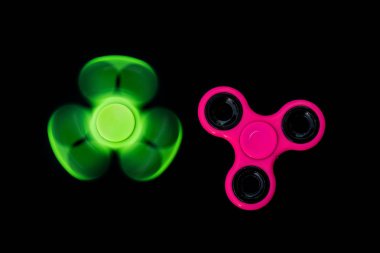 Pembe ve yeşil kıpır Spinner çalışması sırasında stres sürümü için siyah arka plan.