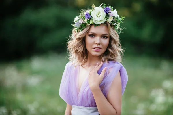 Портрет красивої жінки з вінок з квітами на голові. наречена в фіолетовій сукні на відкритому повітрі. м'який фокус — стокове фото