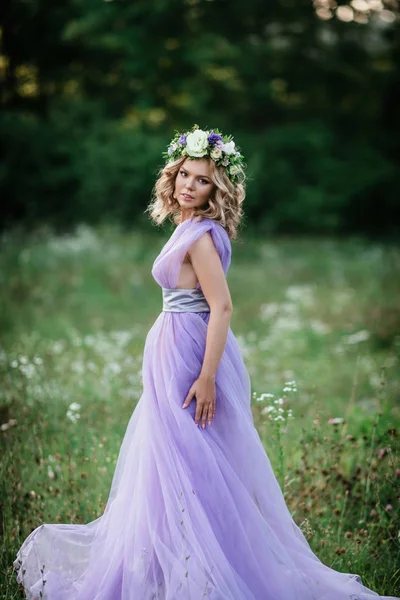 Retrato de mujer de belleza con corona de flores en la cabeza. novia en vestido púrpura al aire libre. enfoque suave —  Fotos de Stock