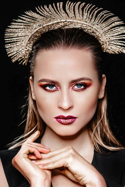 Portret van een meisje met een gouden kroon. Model met creatieve make-up. — Stockfoto