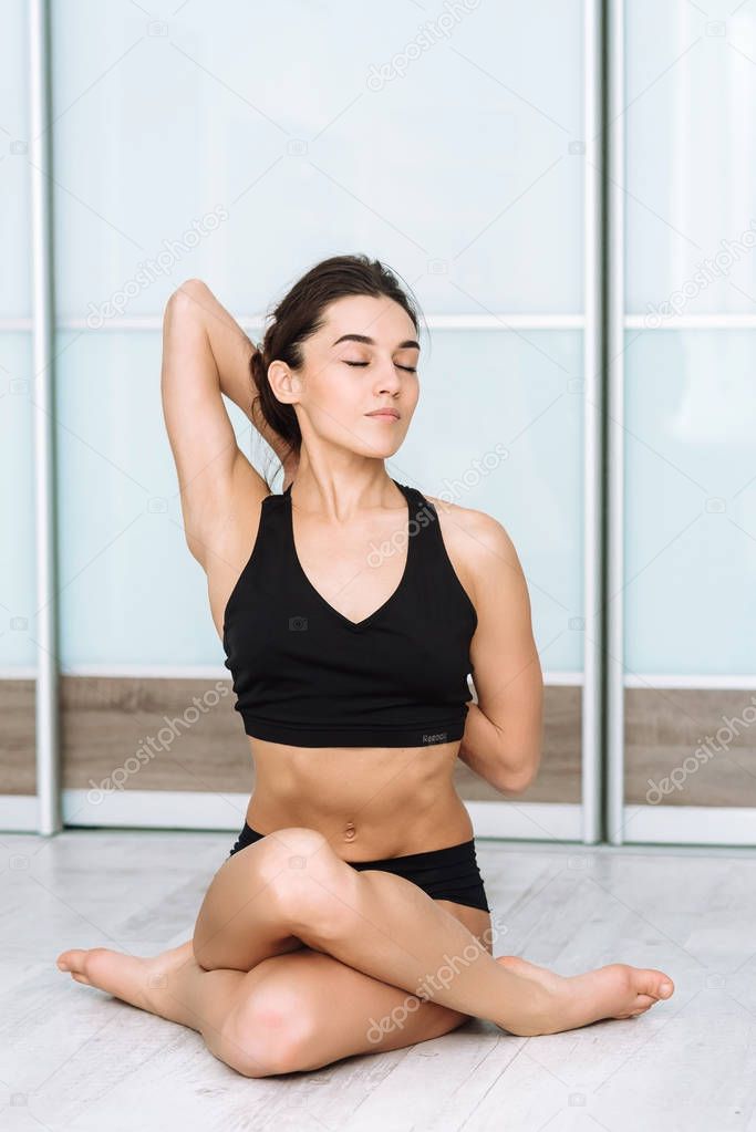 sports model girl doing asanas. beautiful brunette practicing yoga in the interior