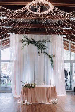 Düğün presidyum restoranında, boş alan. Çiçekler, yeşil, pembe kumaş ve ampuller ile yeni evliler için ziyafet tablo düğün. Düğün masada yemyeşil çiçek aranjman. Lüks düğün süslemeleri