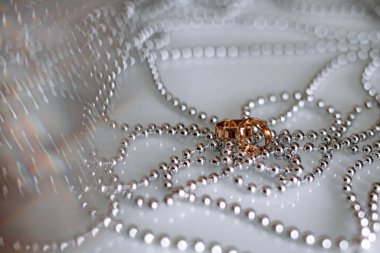 Gümüş boncuklarda altın yüzükler, yakın plan.