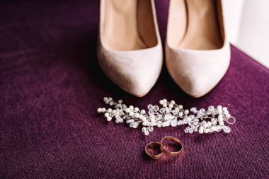 Bej kadın ayakkabıları, iki altın alyans. Düğün konsepti