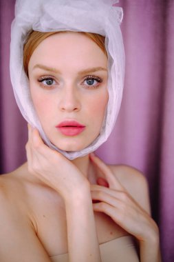 Pembe arka planda bir kızın portresi. Beyaz fularlı genç bir kadın.