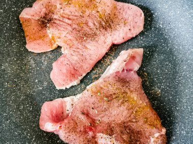 Baharatlı çiğ hindi bifteği tavada kızartılır..