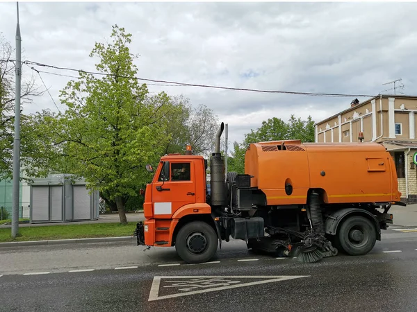 Turuncu süpürge makinesi (sokak süpürücü) şehir yolunu temizler.