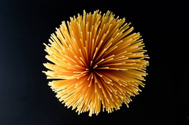 Yere saçılmış çiğ spagettiye bakıyorum.