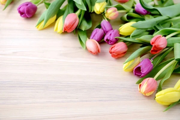 Bunch of colorful tulips on white table with space — Stock Photo, Image