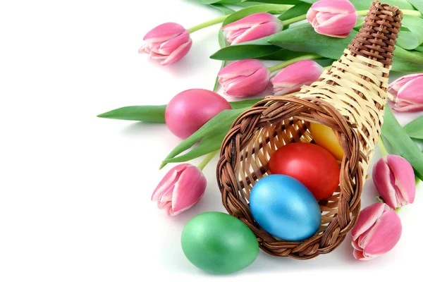 Ovos de Páscoa com uma cornucópia e ramo de tulipas rosa em isolat — Fotografia de Stock
