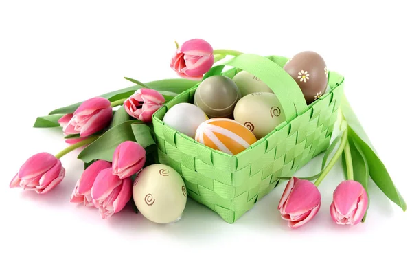 Ovos de Páscoa com uma cesta e um monte de tulipas rosa em w isolado — Fotografia de Stock