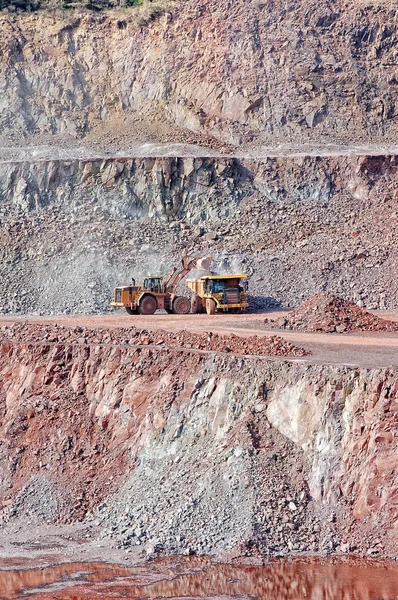 石矿场矿斑岩。推土机自卸车装车 — 图库照片
