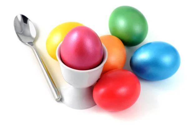 Чашка с пасхальными яйцами и ложкой на белом изолированном фоне — стоковое фото