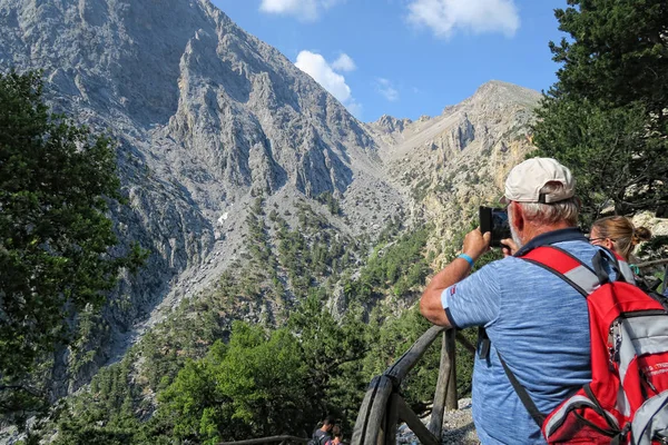 Ο άνθρωπος λήψη φωτογραφιών με το κινητό μέσω πεζοπορώντας στο μονοπάτι throu — Φωτογραφία Αρχείου