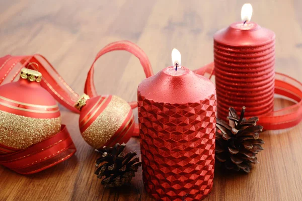 Christmas ball with buring candle and red ribbon — Stock Photo, Image
