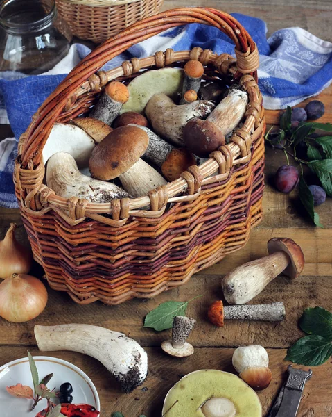 Cesta com cogumelos em uma mesa de madeira . — Fotografia de Stock