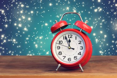 Saat on iki yönünde uçan kar ortasında kırmızı retro çalar saat.