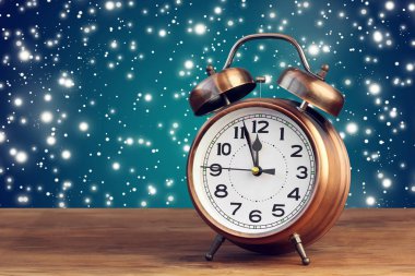 Saat on iki yönünde uçan kar ortasında bronz retro çalar saat.