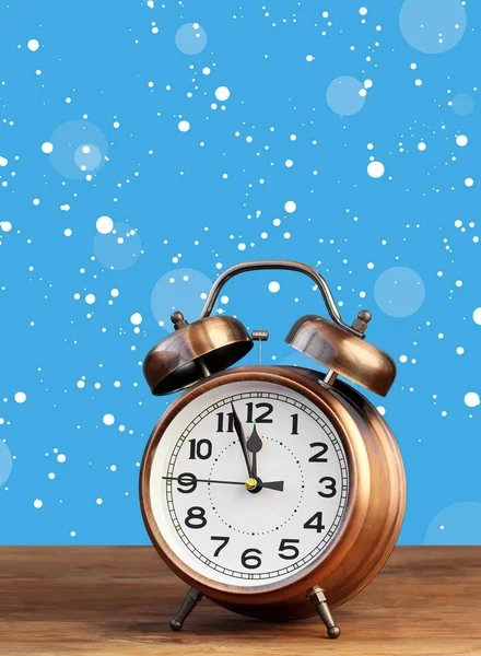 Бронзовый ретро-будильник в двенадцать часов на фоне снега . — стоковое фото