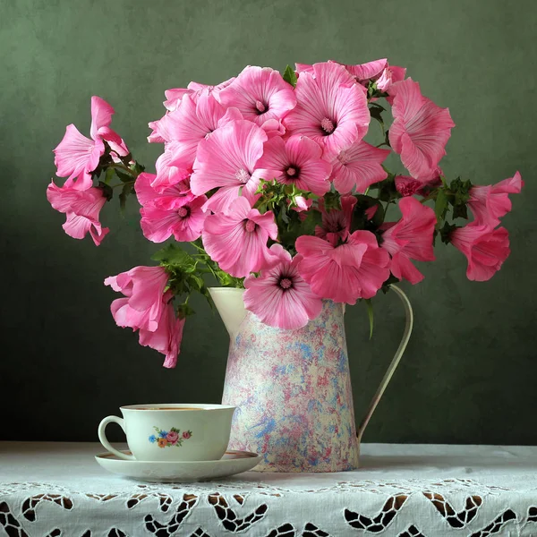 Still-life with a bouquet in a jug and a cup of retro. — Stock Photo, Image