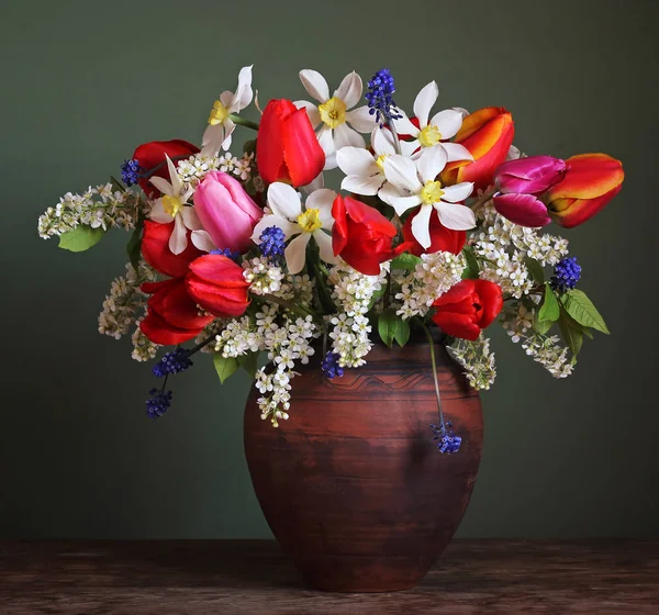 Still life with a spring bouquet in a clay jar. — Stock Photo, Image