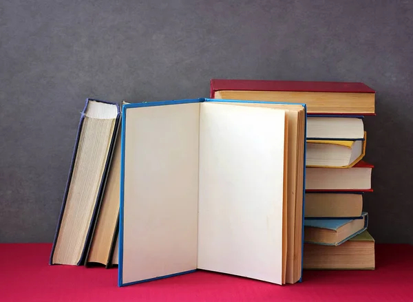 Pilha de livros na mesa com uma toalha de mesa vermelha . — Fotografia de Stock