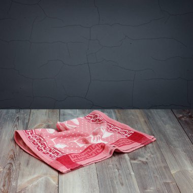 Gri bir duvara bir havlu ile boş ahşap masa.