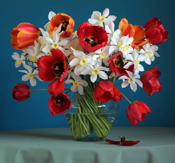 Kytice narcisy a tulipány na stůl. — Stock fotografie