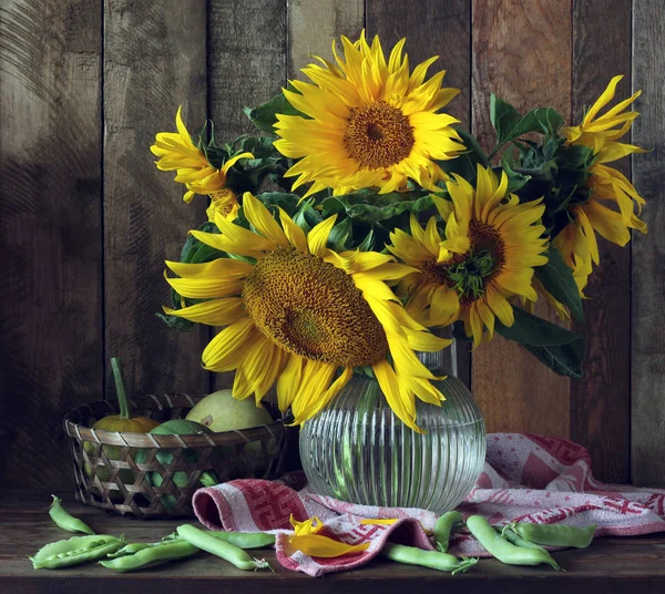 Zonnebloemen, pompoenen en erwten op tafel — Stockfoto