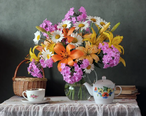 Country still life with lilies and utensils for tea. — Stock Photo, Image
