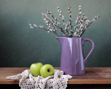 bir sürahi ve elma yeni gelişen bir söğüt dalları