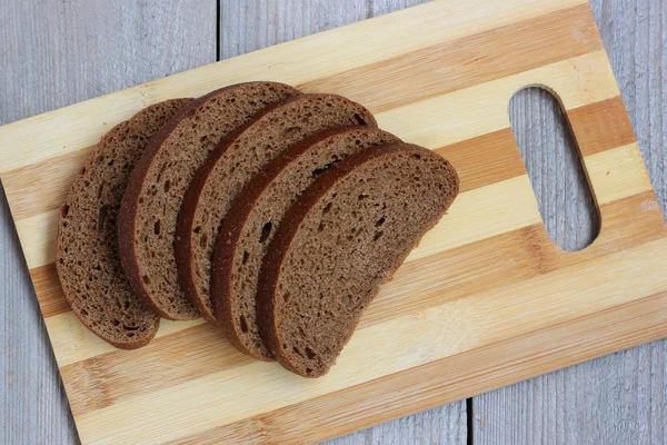 Çavdar ekmeği bir kesme tahtası üzerinde parçaları. — Stok fotoğraf