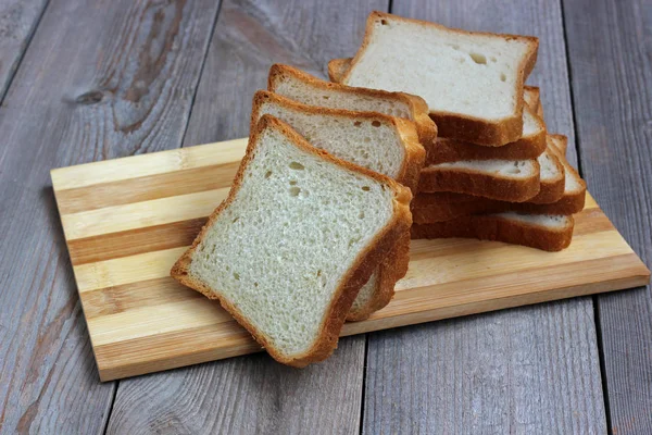 Шматочки пшеничного хліба на обробній дошці . — стокове фото