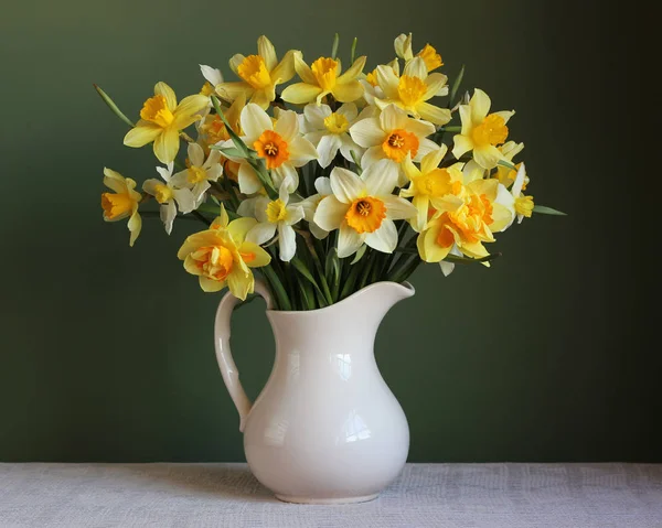 Buquê de narcisos amarelos em um jarro branco — Fotografia de Stock