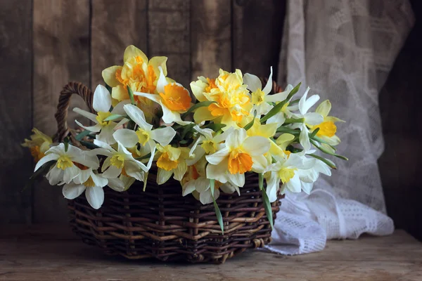 Narcisos amarelos em uma cesta na mesa . — Fotografia de Stock