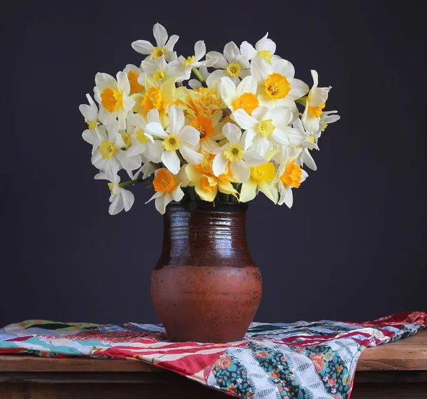 Ramo de narcisos de jardín fresco en una jarra de barro sobre la mesa . —  Fotos de Stock