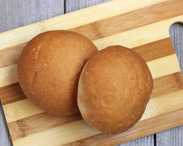 Bir kesme tahtası üzerinde iki rulo. Kepekli ekmek. — Stok fotoğraf