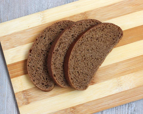 Three pieces of rye bread on a cutting Board. — Stock Photo, Image