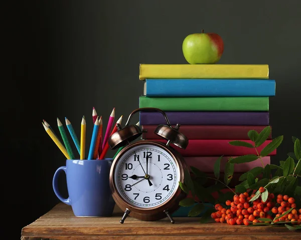 Montón de libros en cubiertas de colores, lápices, despertador y un sujetador — Foto de Stock