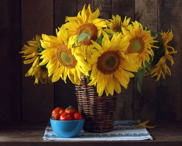 Strauß Sonnenblumen im Korb und Tomaten. — Stockfoto