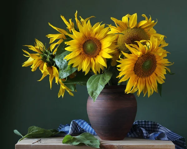 Bouquet of sunflowers in a clay jug. — Stock Photo, Image