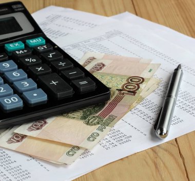 Sayfa numaraları ile kağıt üzerinde hesap makinesi ve Rus para.