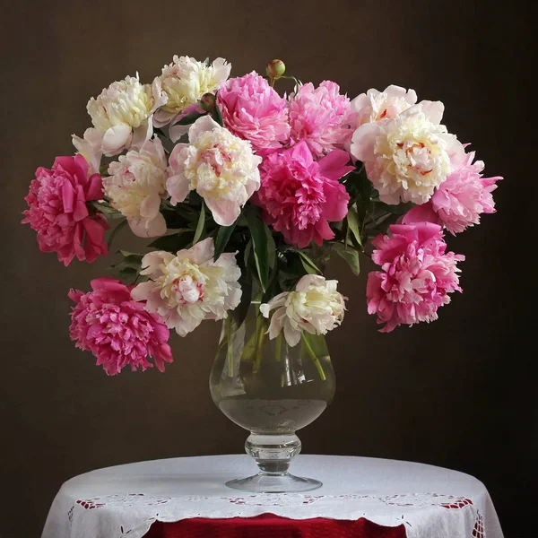 Weelderige boeket van roze pioenrozen in een vaas op tafel. — Stockfoto