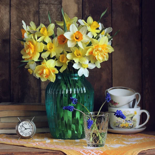 束黄色的水仙花在蓝色玻璃花瓶. — 图库照片