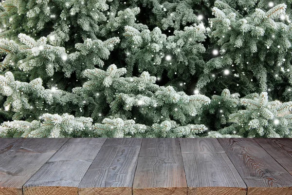 Порожня дерев'яна стільниця на фоні гілок ялинки зі снігом — стокове фото