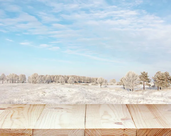 Trä bordsskiva mot bakgrund av ett vinterlandskap. — Stockfoto