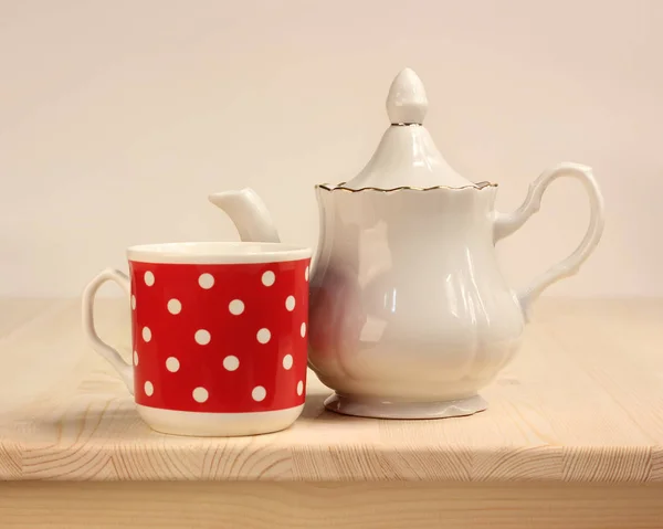 Белый чайник и кружка красный с горошек точками . — стоковое фото